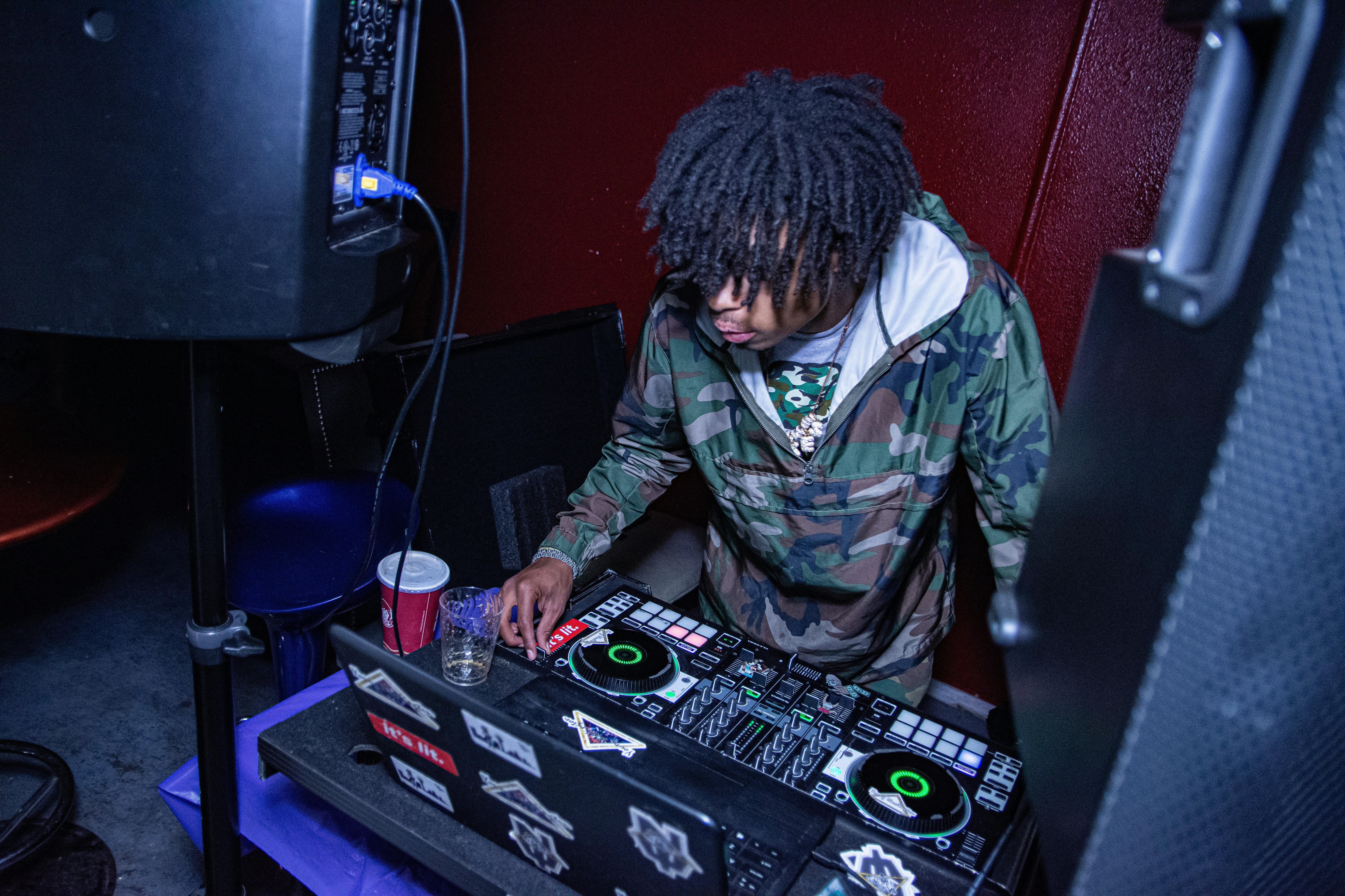 man in green and brown camouflage jacket playing dj controller